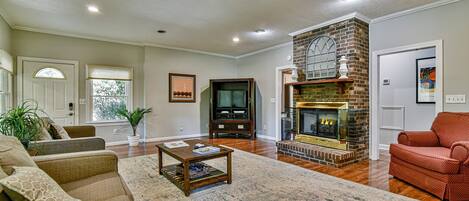 Una sala de estar con chimenea, televisión y sofá.