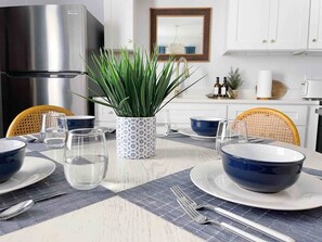 A dining table set with blue bowls, clear glasses, and a patterned placemat.