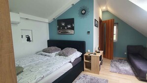Ein Schlafzimmer mit Bett, Nachttisch, Kommode, Fenster und Tür.
