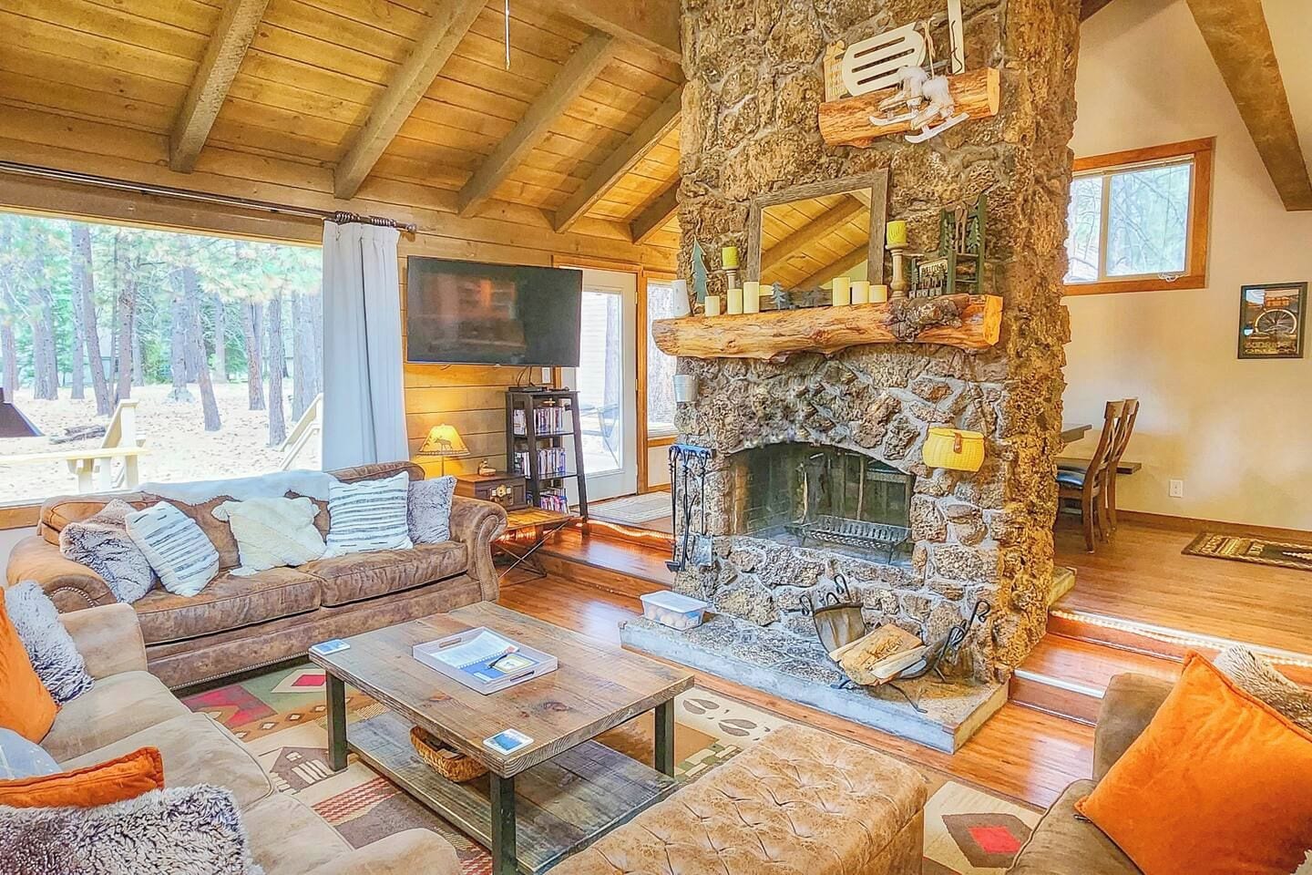Ein gemütliches Wohnzimmer mit Kamin, einer bequemen Couch und einem Fernseher.