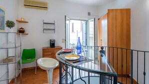 Een eethoek met een glazen tafel, stoelen en uitzicht op het exterieur.