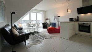 A modern apartment with a dining area, kitchen, and living space.