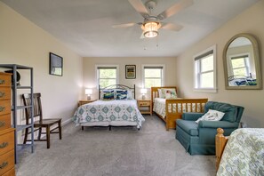 A bedroom with a bed, a chair, a dresser, a ceiling fan, and two windows. - Vermont Vacation Rental: Hot Tub, Near Ski Resorts (Mt Holly)