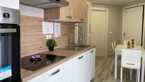 A modern kitchen with a built-in oven, a stainless steel sink, and a wooden countertop.