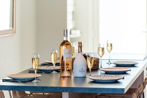 A dining table with a bottle of wine, glasses, and plates.