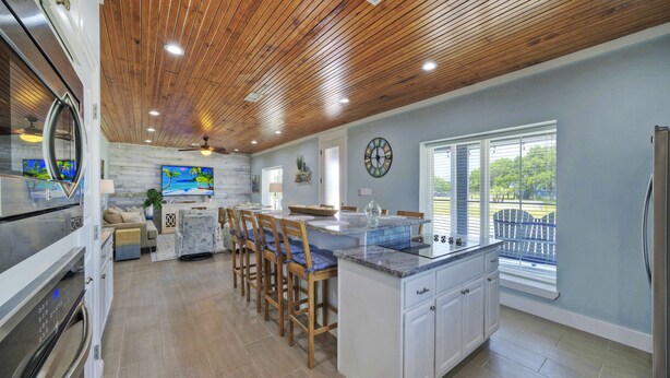 Una cocina con techo de madera, una isla grande y vistas al exterior.