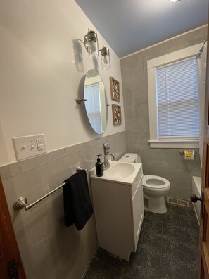 A bathroom with a white sink, a toilet, a mirror, and a towel rack. - Central access to all of the wonders of the Shenandoah Valley! (Shenandoah)