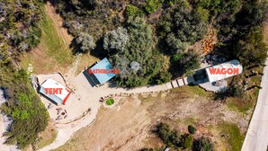 An aerial view of a campsite with a tent, a bathroom, and a wagon.