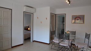 A room with a bed, a dining table with chairs, and an air conditioning unit. - Alicante 1 - L'Estartit, Center (Estartit (L´))