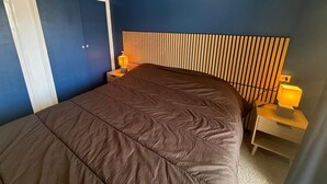 A bedroom with a large bed, a wooden headboard, two bedside tables with lamps, and built-in wardrobes. - Alicante 1 - L'Estartit, Center (Estartit (L´))