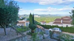 A residential area with stone pathways, a palm tree, and houses with tiled roofs. - CASA JOSI with awesome views to the sea at Monte Pego (Pego)