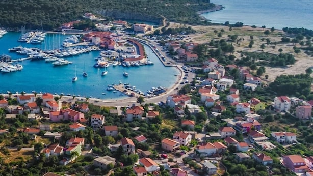 A coastal town with a marina, houses, and a hilly backdrop. - Seafront apt with terrace, 4 bedrooms and mooring (Rogoznica)