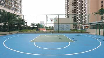 An outdoor basketball court surrounded by high-rise residential buildings.