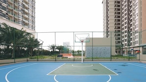 Una cancha de baloncesto al aire libre rodeada de edificios residenciales altos.