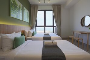 A hotel room with two beds, a desk, and a view of the beach. - Bali Deluxe Melaka By I Housing  (Malacca City)