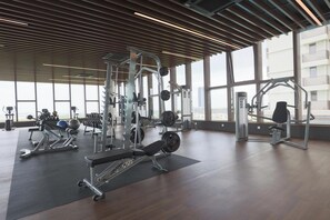A gym with various exercise equipment, large windows, and a wooden ceiling. - Bali Deluxe Melaka By I Housing  (Malacca City)