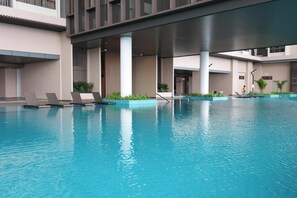 A swimming pool with lounge chairs and a covered area. - Bali Deluxe Melaka By I Housing  (Malacca City)