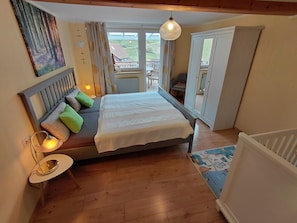 Un dormitorio con cama, lámparas de noche, una ventana y vistas al exterior.