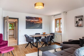 Un salon moderne comprenant un coin repas, un canapé, une table et des chaises.
