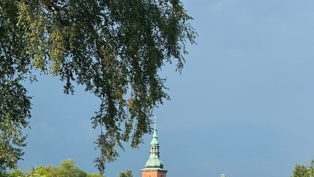 A serene lakeside view with a church steeple, boats, and lush greenery. - Apartment by the Park Lake with Lake Access (Bad Bodenteich)