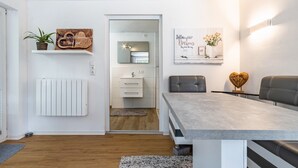 A modern kitchen with white cabinetry, a built-in oven, and a countertop. - Apartment by the Park Lake with Lake Access (Bad Bodenteich)