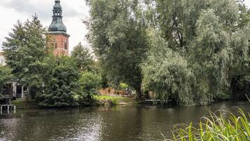 Een rustgevende rivieroever met een historisch pand en een klokkentoren.
