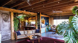Un'ampia zona giorno con soffitto in legno, una grande statua di Buddha, un divano e un tavolino da caffè.