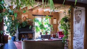 Un accogliente soggiorno con camino, un pianoforte e diverse piante in vaso.