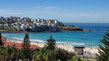 A coastal town with a beach, buildings, and a clear sky.
