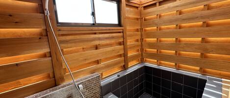 L’intérieur d’un chalet en bois, avec une baignoire d’angle, des murs en bois et une fenêtre.