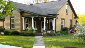 A two-story house with a front porch, a stone facade, and a well-maintained lawn. - 115 yr old Historic Heffner House in Downtown Rogers (Rogers)