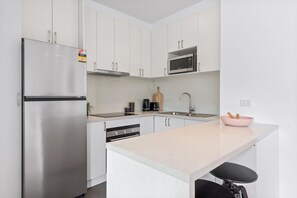 Enjoy cooking in this well-equipped kitchen with a refrigerator, microwave, sink, and coffee maker.
