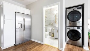 A modern kitchen with stainless steel appliances, a marble backsplash, and hardwood flooring. - Luxe Family Home/2 kitchens & Living Rooms/Balcony (Louisville)