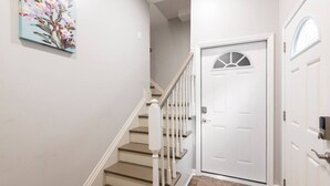 A staircase with white railings and beige steps leading to a white door with a glass panel. - Luxe Family Home/2 kitchens & Living Rooms/Balcony (Louisville)