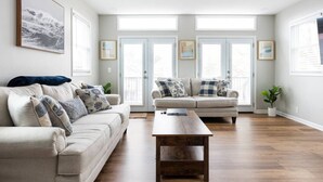 A spacious living room with two sofas, a coffee table, and large windows. - Luxe Family Home/2 kitchens & Living Rooms/Balcony (Louisville)