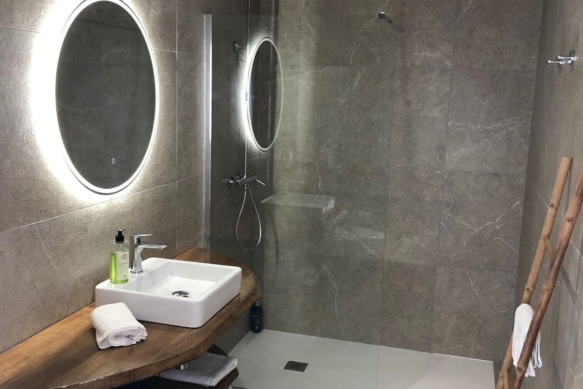 deluxe room | bathroom | shower, hydromassage showerhead, hair dryer, towels