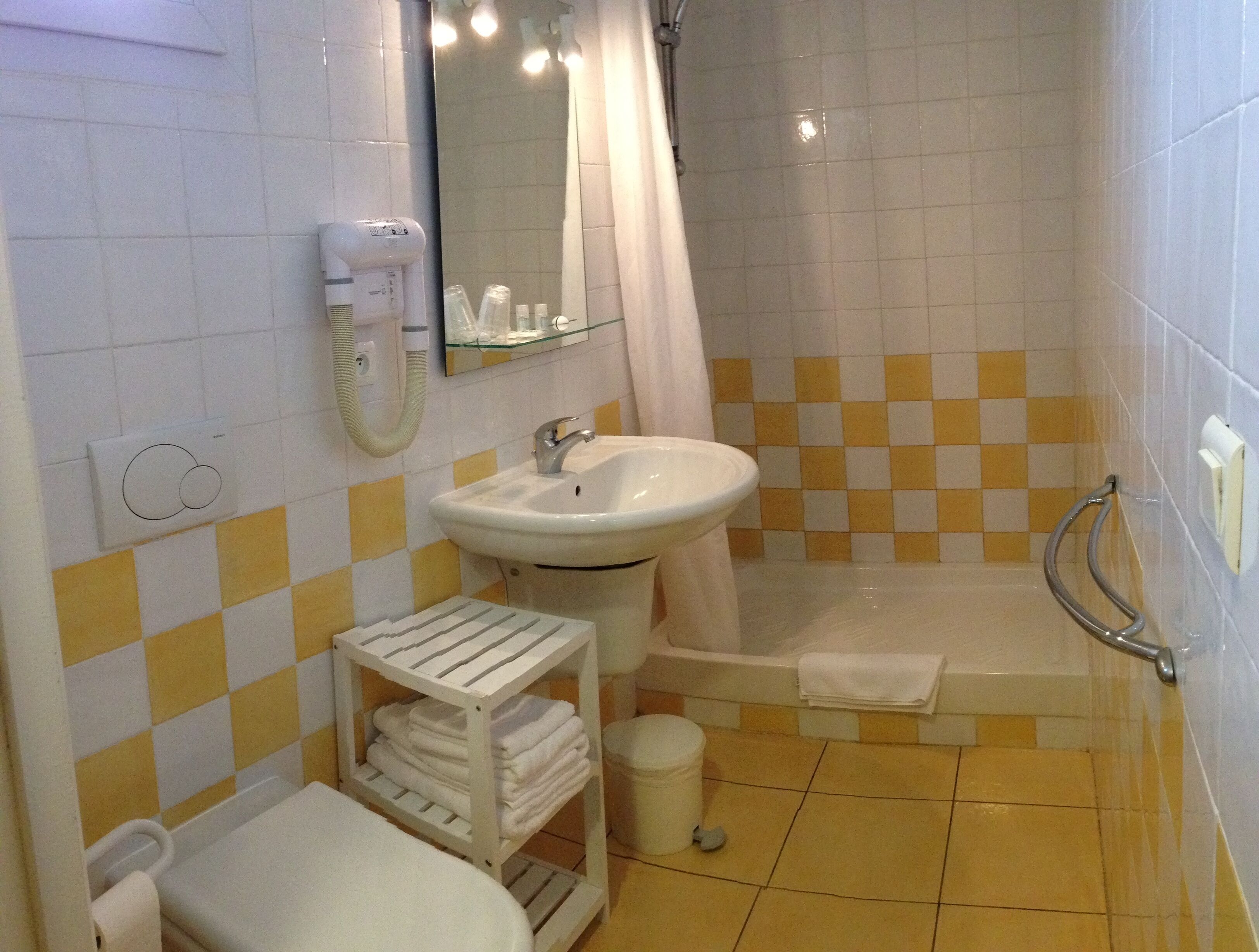 Un baño con lavabo, espejo, ducha y perchero.
