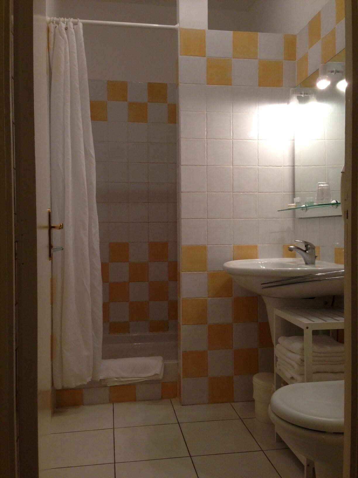 Un baño con ducha, lavamanos e inodoro.