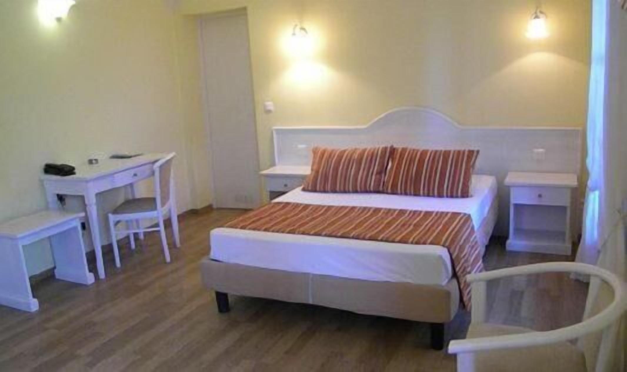 Une chambre à coucher avec un lit, deux tables de chevet, un bureau et une chaise.