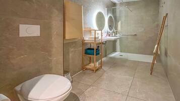 Une salle de bain moderne équipée de toilettes, d’un lavabo, d’une douche et d’un miroir.