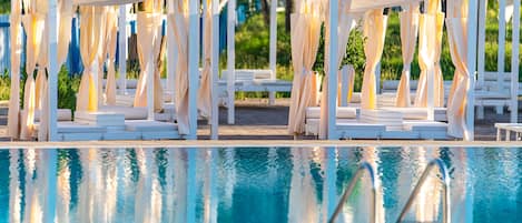 Una piscina al aire libre de temporada, sombrillas