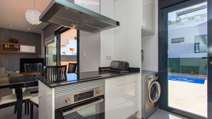 Eine moderne Küche mit Einbauofen, Mikrowelle und Waschmaschine.