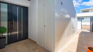 Ein modernes Gebäude mit Glasfassade, einer schwarzen Tür und einem Blumentopf.