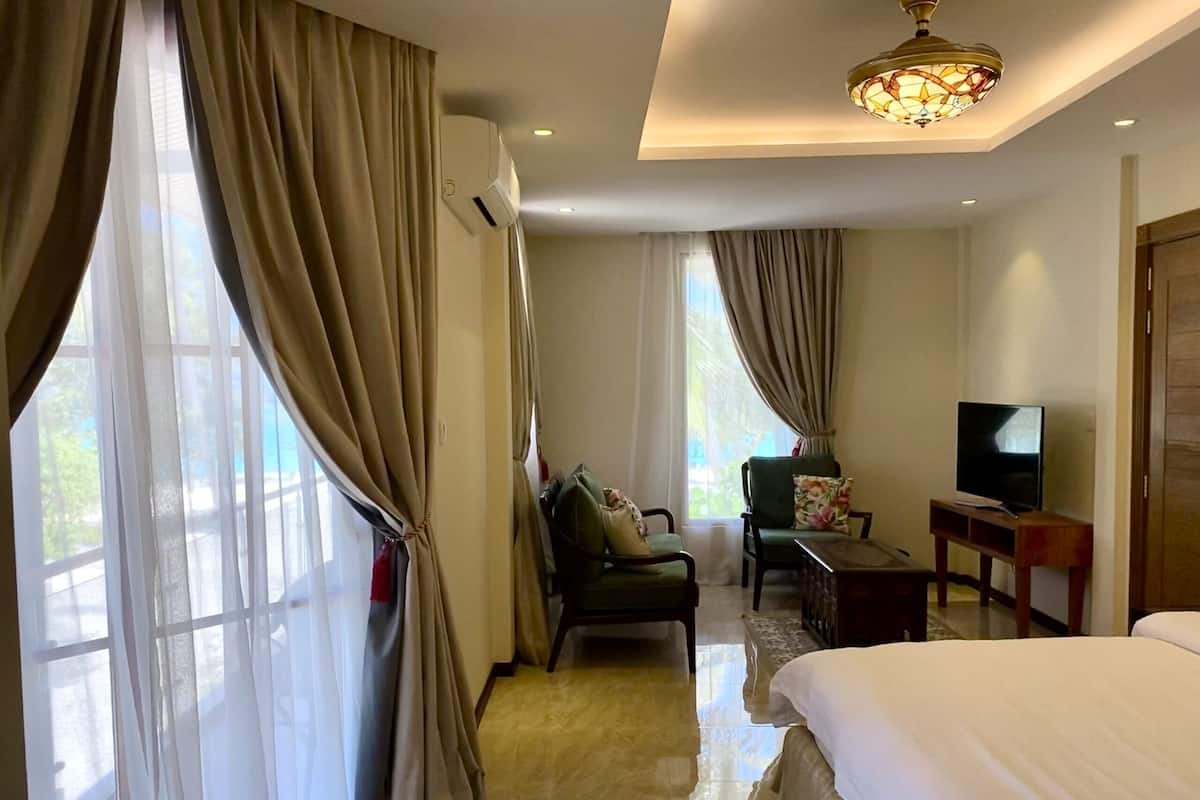 A hotel room with a bed, a television, a desk, and a chair.