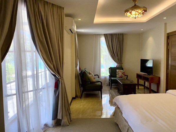 Una habitación de hotel con cama, televisión, escritorio y silla.
