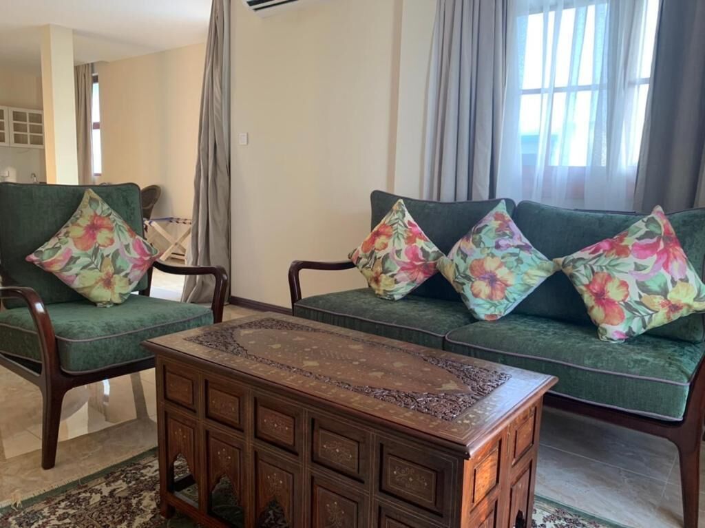 Una sala de estar con un sofá, cojines estampados y una mesa de centro de madera.