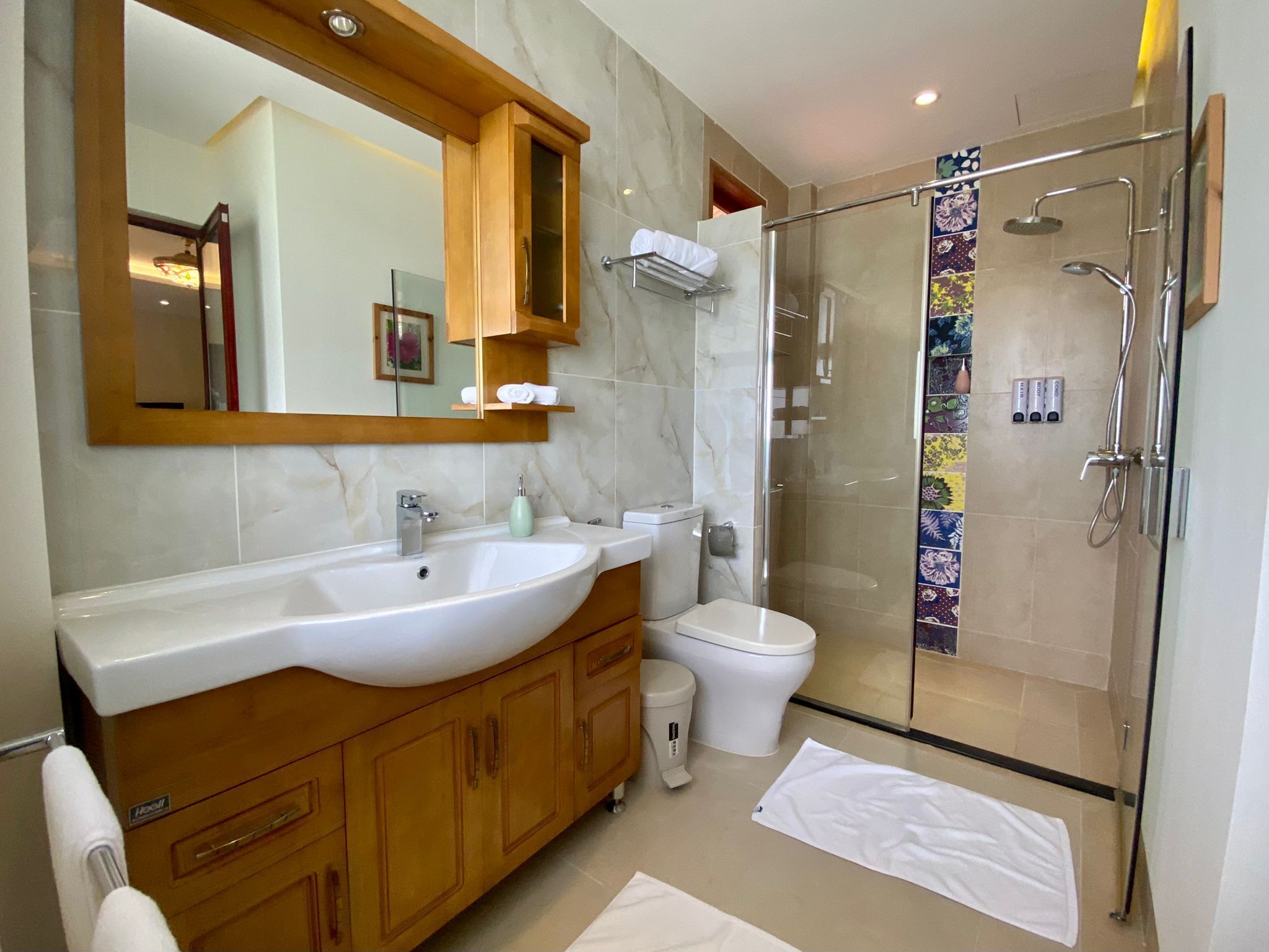 Une salle de bain avec un grand lavabo, des toilettes, une douche et un miroir.