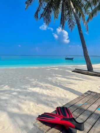 On the beach, white sand, sun-loungers, beach umbrellas. ViluVeli Holiday Retreat