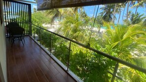Un balcón con vista a una playa y palmeras.