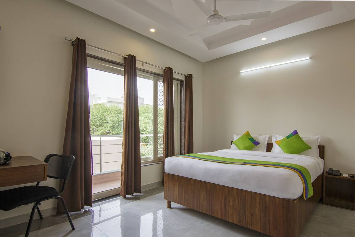A bedroom with a bed, a desk, and a chair.